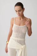 Woman wearing white boucle knit top.