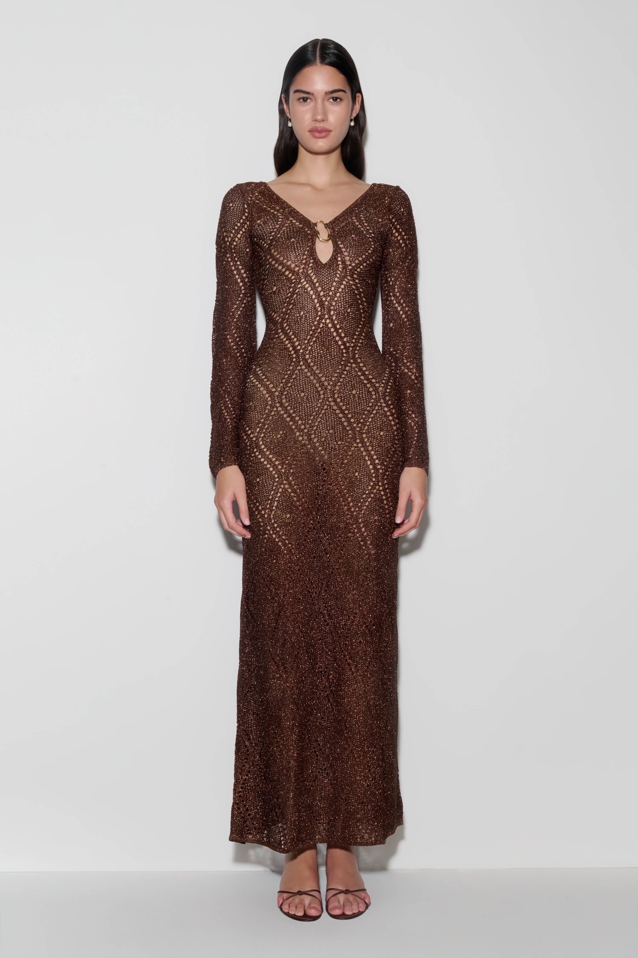 Woman wearing a brown lurex crochet maxi dress.